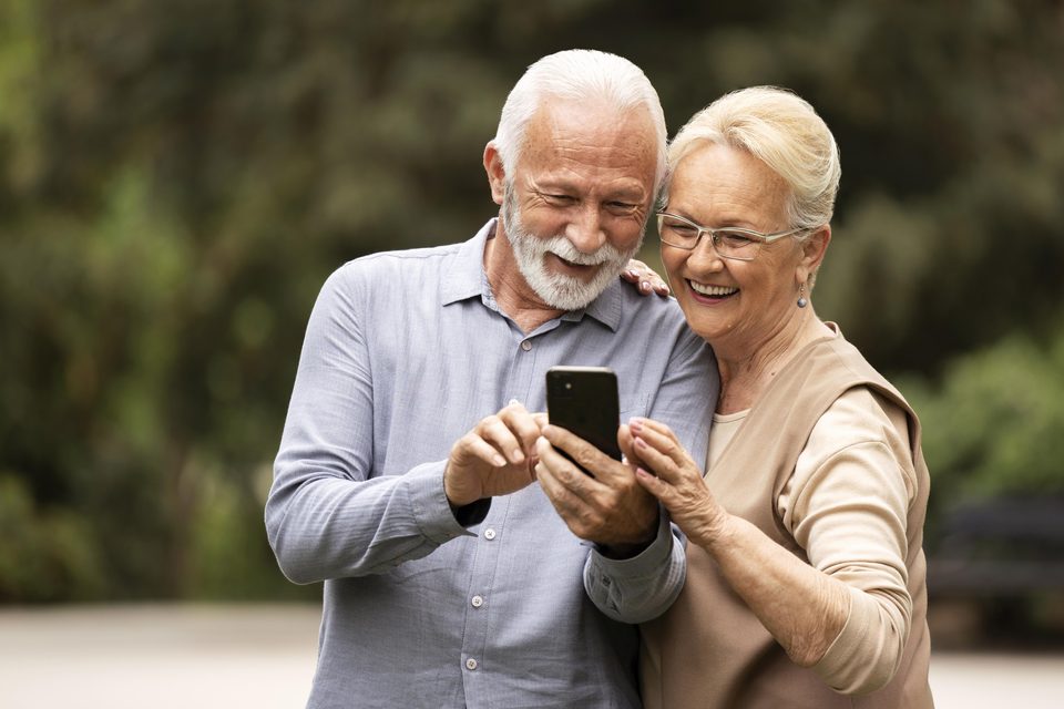 An older couple smiling at a smartphone