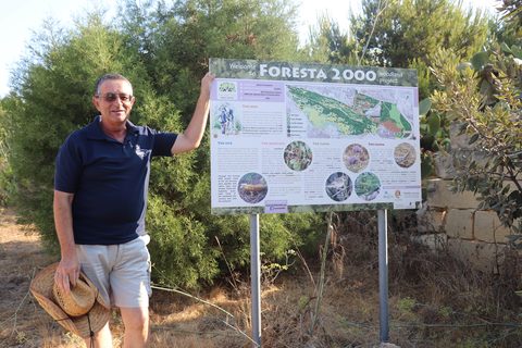 Raymond Vella standing next to a Foresta 2000 information board