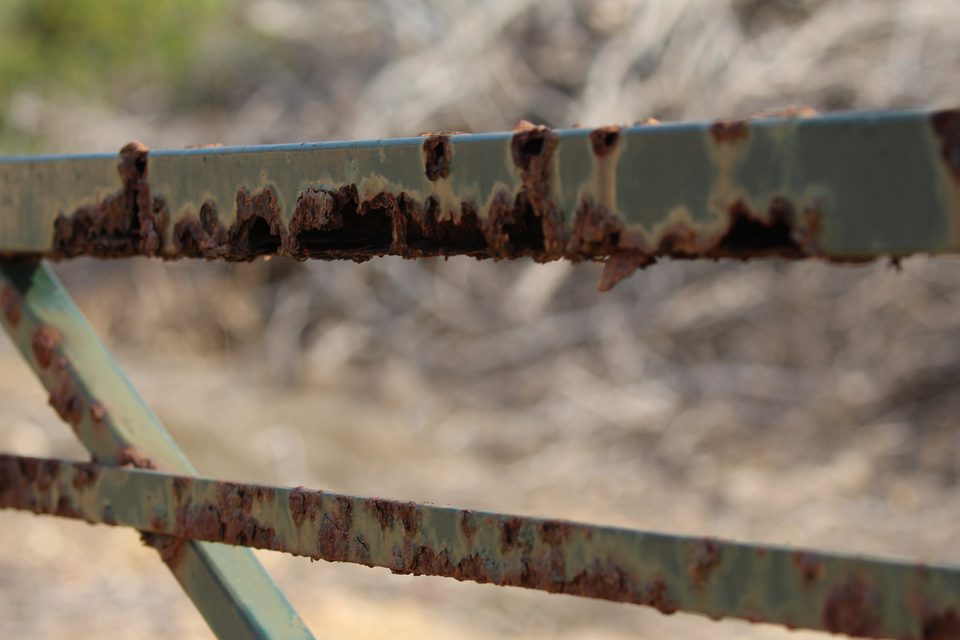 A close-up of a badly rusted metal gate