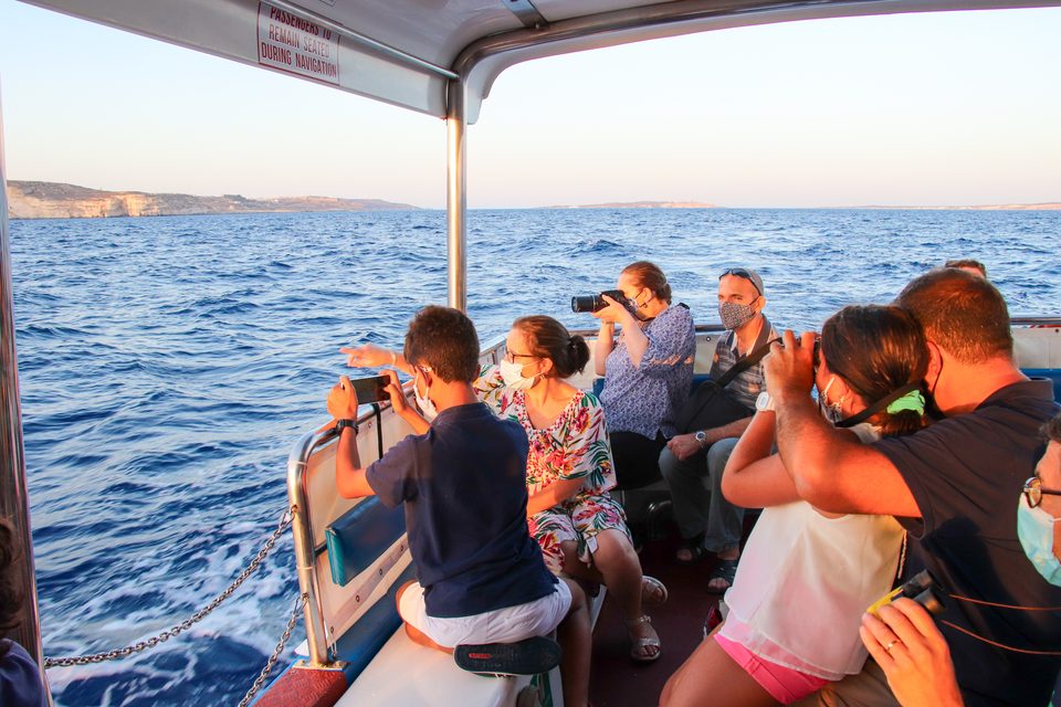 People with binoculars watching from a boat at sea