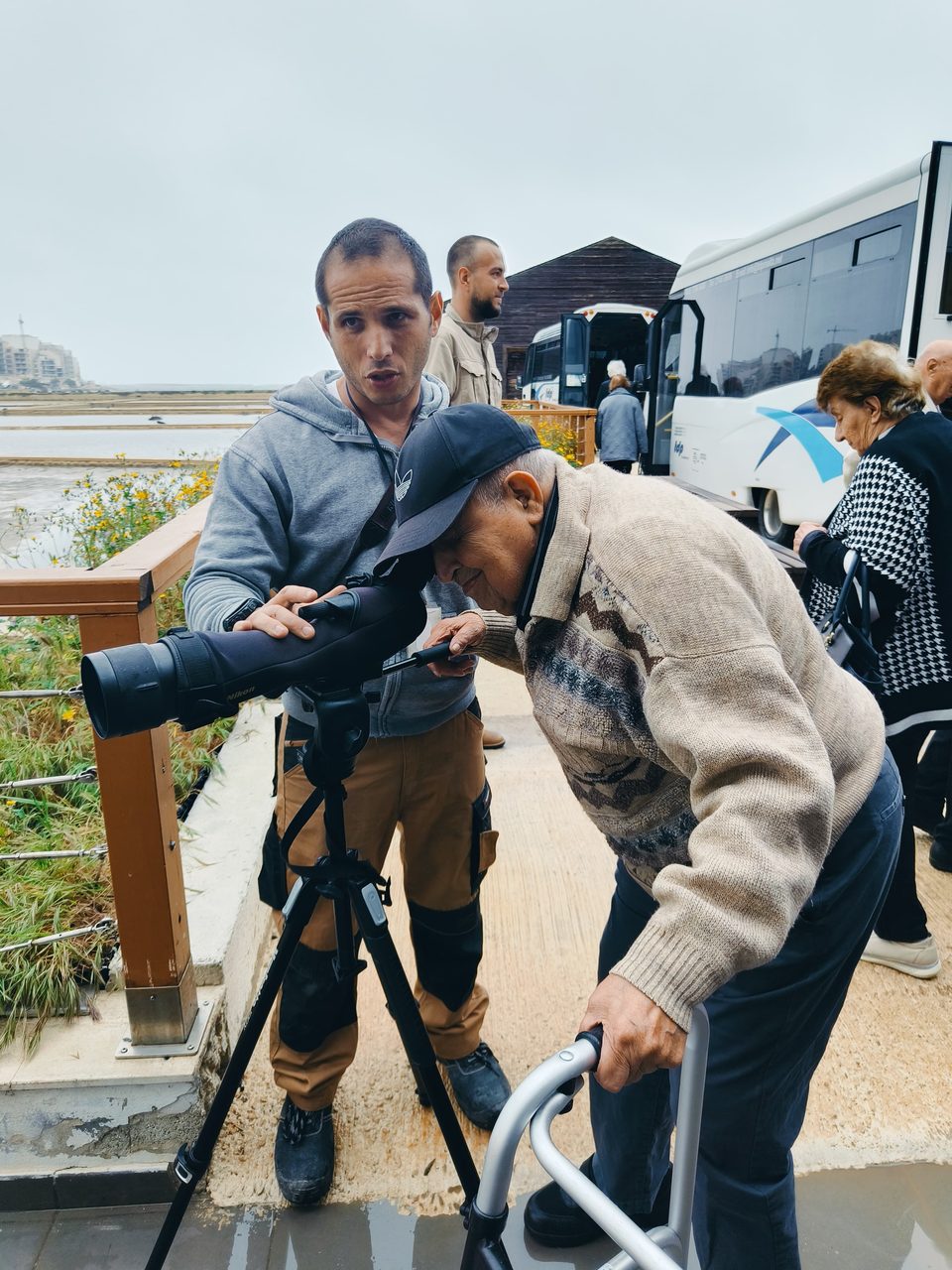 Older participants looking through a spotting scope on a ROOTED outing