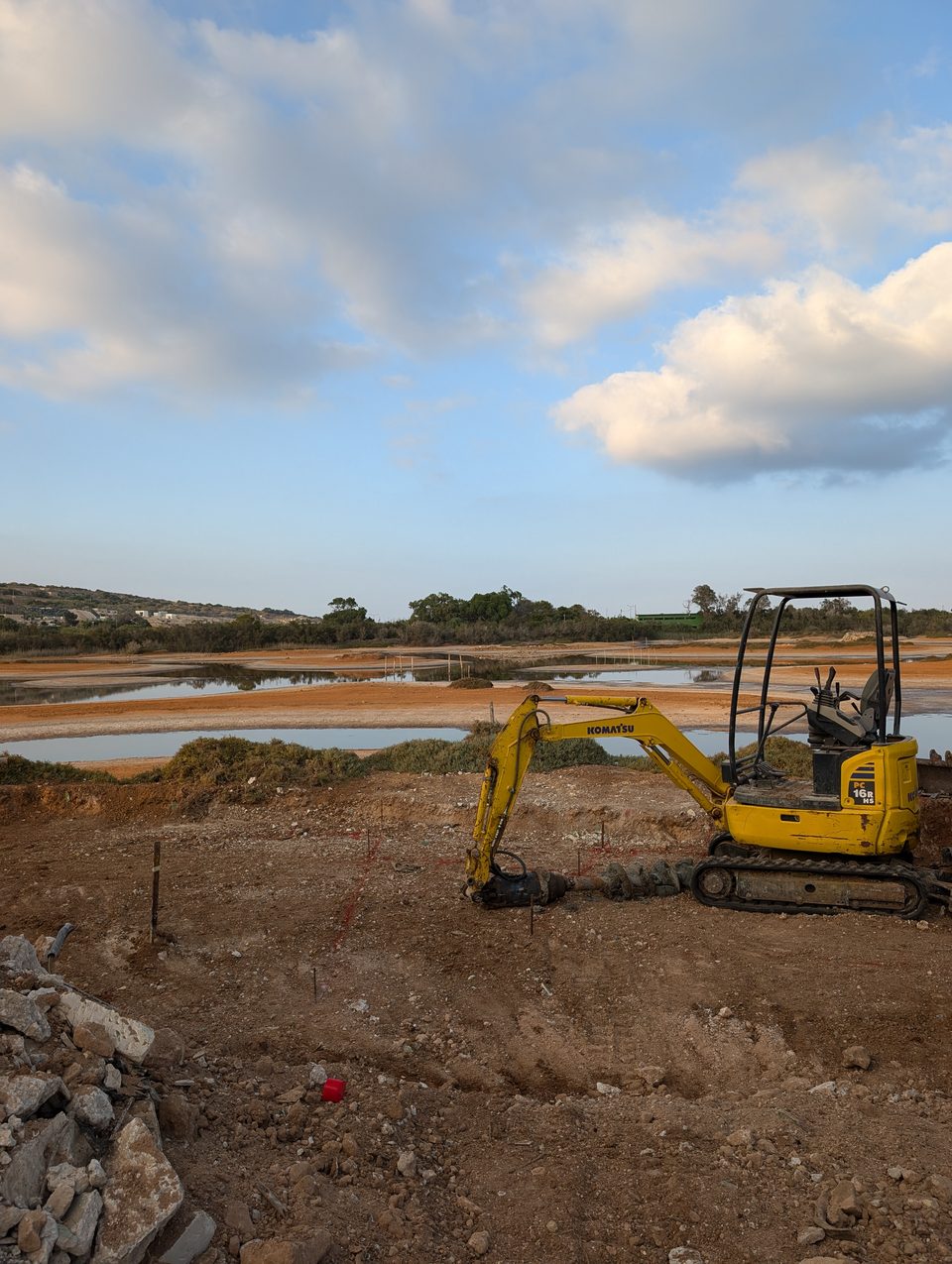 A small excavator working on a wetland restoration site