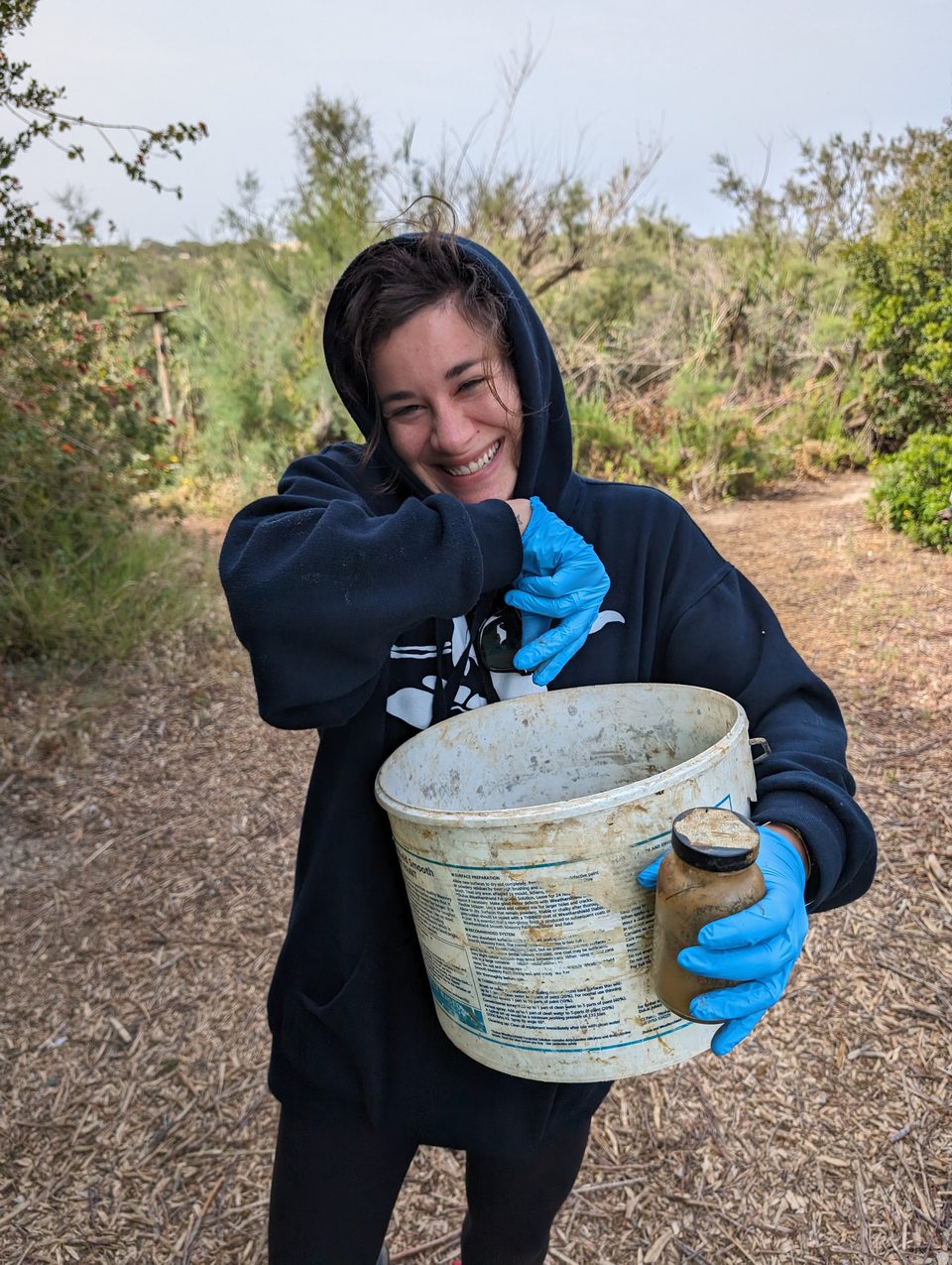 A volunteer holding an old bucket of collected litter