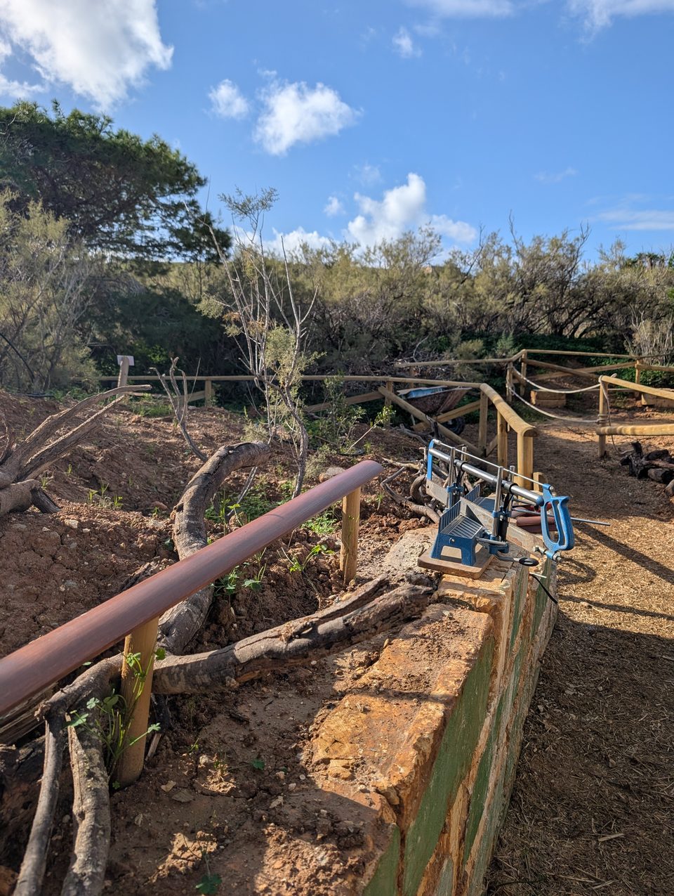 Pipes and a pump beside a wooden handrail
